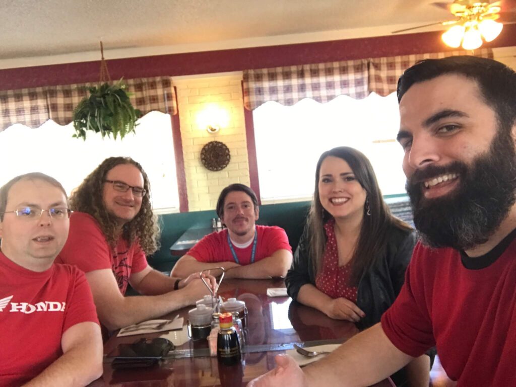 Five members of BigWing Interactive's Web Team sit around a table enjoying a lunch out